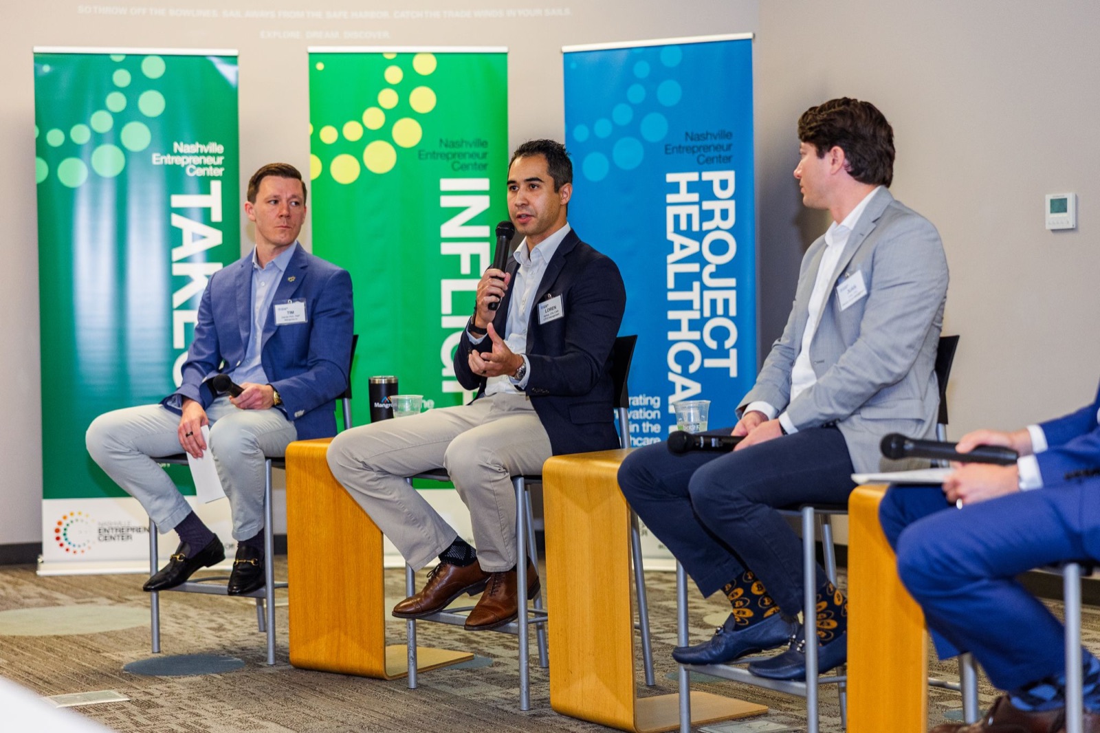 Panelists listening as one speaks into a microphone