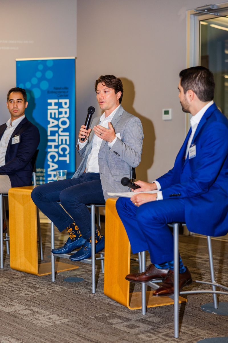A panelist speaking with the moderator beside him